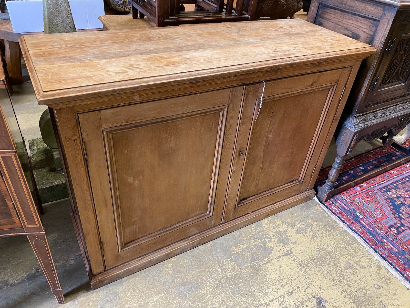 A Victorian pine two door side cabinet, width 124cm, depth 44cm, height 84cm